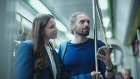 Caucasian man with beard wearing blue sweater holding smartphone showing screen to smiling woman in blue coat. Couple standing on city bus watching video together during evening ride. - Powered by Shutterstock - Get 15% off with code: PIKWIZARD15