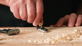 A person is using a hand plane on a piece of wood in a workshop. Wood shavings accumulate on the surface, showcasing a focus on craftsmanship and detail. - Powered by Shutterstock - Get 15% off with code: PIKWIZARD15