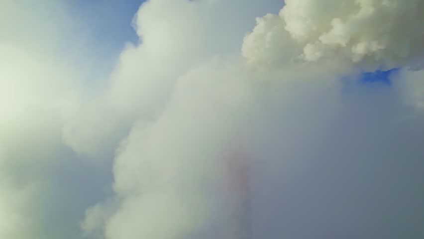 A visually stunning display of vapor clouds billowing over a mountainous landscape. The early morning light creates a peaceful atmosphere as the clouds gently drift, showcasing nature