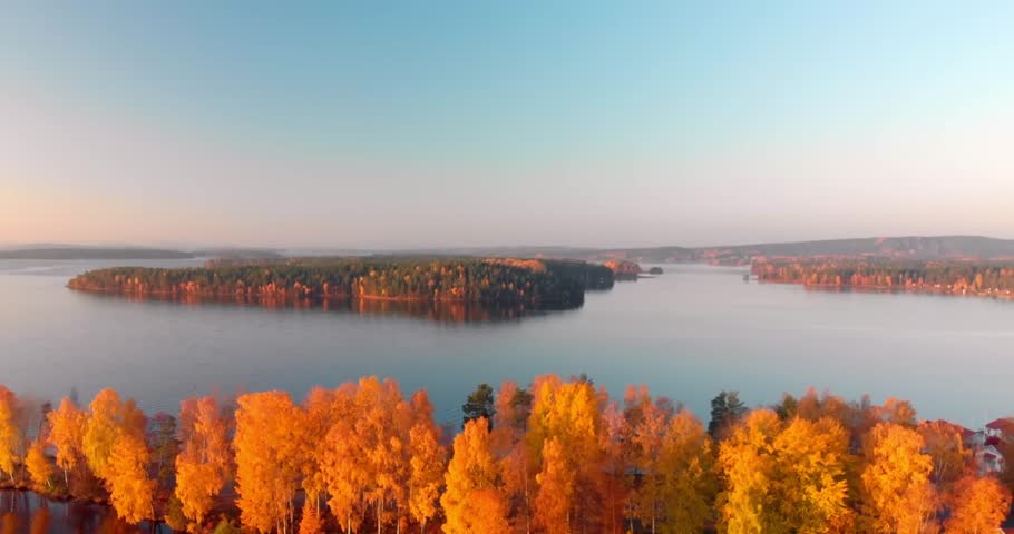 A lake surrounded by trees in autumn colors under a clear blue sky.