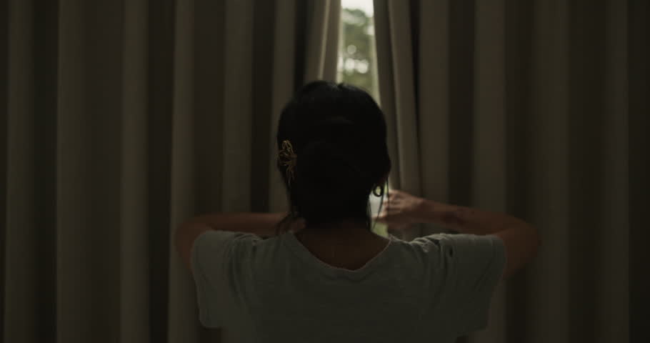 Back, woman and open curtain at house to start day, waking up and morning routine for sunshine. Person, awake or sunlight with drapes of window for fresh air, check weather and garden view in bedroom