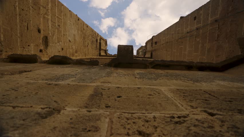 Ruins of a historic church in Northern Cyprus, showing ancient stone architecture, arched windows, and detailed masonry under a clear blue sky