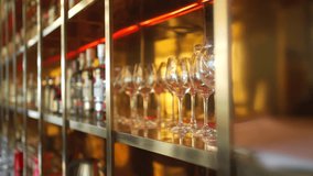 Female bartender wiping and polishing glasses arranged on shelves behind the bar counter, preparing for opening time, representing hospitality service. Restaurant business lifestyle concept. - Powered by Shutterstock - Get 15% off with code: PIKWIZARD15