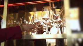 Female bartender wiping and polishing glasses arranged on shelves behind the bar counter, preparing for opening time, representing hospitality service. Restaurant business lifestyle concept. - Powered by Shutterstock - Get 15% off with code: PIKWIZARD15
