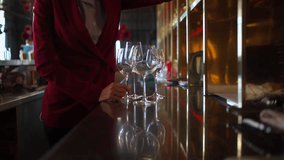 Female bartender wiping and polishing glasses arranged on shelves behind the bar counter, preparing for opening time, representing hospitality service. Restaurant business lifestyle concept. - Powered by Shutterstock - Get 15% off with code: PIKWIZARD15