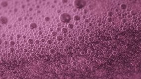 Macro view of countless pink microbubbles swirling and rising through a shimmering liquid, forming a foam texture. Ideal 4K footage for beauty, cosmetics, spa, science visuals, and creative backdrops. - Powered by Shutterstock - Get 15% off with code: PIKWIZARD15