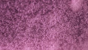 Macro view of countless pink microbubbles swirling and rising through a shimmering liquid, forming a foam texture. Ideal 4K footage for beauty, cosmetics, spa, science visuals, and creative backdrops. - Powered by Shutterstock - Get 15% off with code: PIKWIZARD15