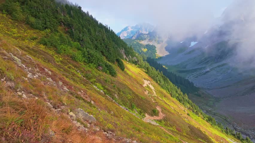 A scenic and expansive view of the majestic North Cascades mountain range, captured from the Sahale Arm along the Cascade Pass Trail