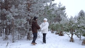 Romantic senior couple holding hands and walking together through a beautiful snowy forest. Happy mature man and woman enjoying a walk in winter - Powered by Shutterstock - Get 15% off with code: PIKWIZARD15