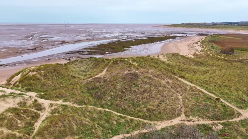 An aerial view of the sand dunes and beach at Hightown near Liverpool, Merseyside towards the River Alt estuary.