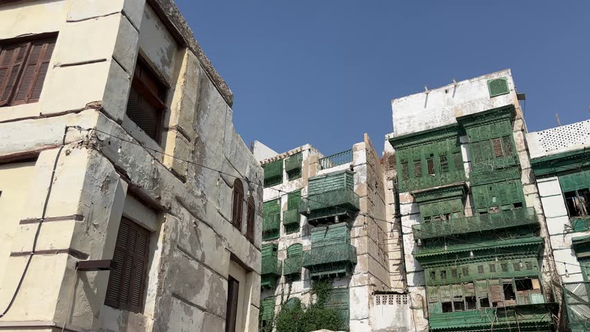 Aerial and street view of traditional coral stone buildings in Al-Balad, the historic district of Jeddah, Saudi Arabia. The UNESCO World Heritage site showcases authentic Hijazi architecture and rich 