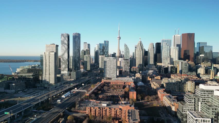 Aerial panoramic view of Toronto city center with CN Tower, lake horizon, and clear vivid daylight. Ideal for tourism stock, urban storytelling, and skyline openers