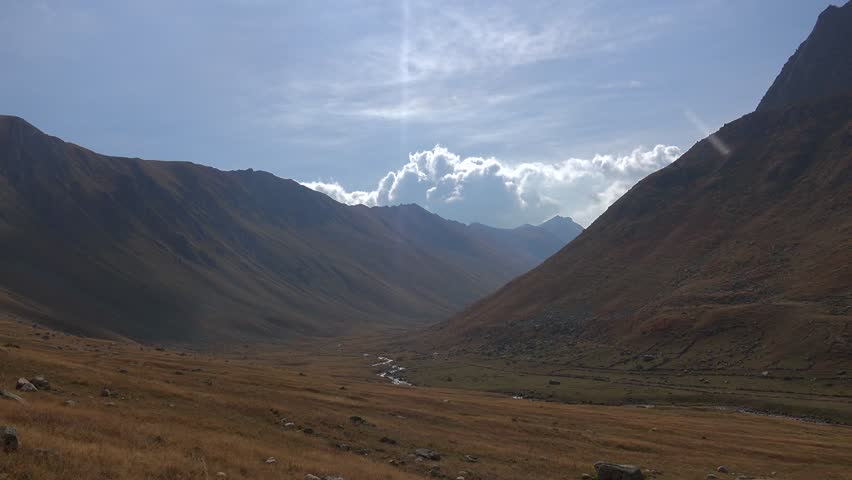 Time-lapse view of a treeless wide valley in the Ethiopian Simien Mountains. High-altitude plateaus and rugged slopes create dramatic African highland scenery under moving clouds.