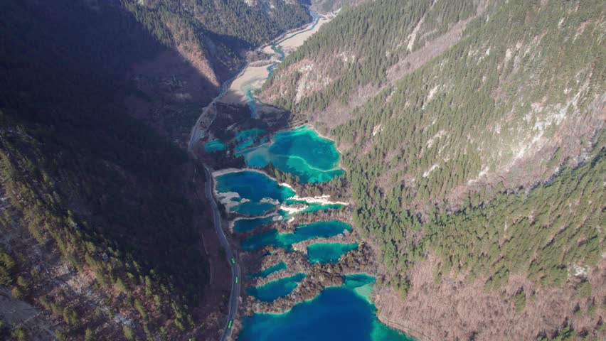 Drone view of Jiuzhaigou National Park in spring in Sichuan Province China. It features cascading waterfalls, turquoise blue lakes, and stunning mountain valleys. 4K real time footage travel concept.