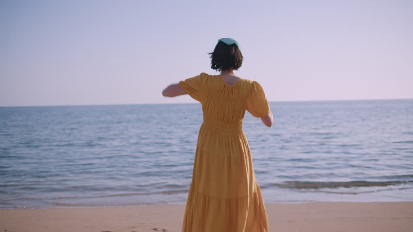 Young Woman Standing by the Sea and Looking into the Distance at Scenic Horizon