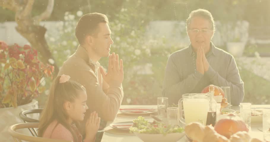 Family praying and initiating finance icons appearing around father before breakfast. Family, outdoor, demographic, digital, technology, lifestyle, harmony