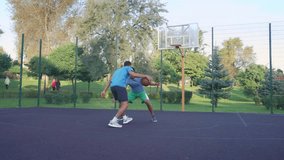 Motivated handsome black male basketball player dribbling ball, driving to the hoop against rival and scoring field goal with layup shot while playing streetball game outdoors. - Powered by Shutterstock - Get 15% off with code: PIKWIZARD15