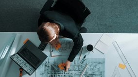 Top view of relaxed smart civil engineer lie on chair at table with blueprint in break time. Aerial view of architect engineer sleeping and relax after working on laptop and equipment. Alimentation. - Powered by Shutterstock - Get 15% off with code: PIKWIZARD15