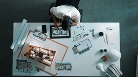 Top view of business man using tablet plan house design while sitting at meeting table with blueprint and equipment scatter around. Aerial view of civil engineer working at blueprint. Alimentation. - Powered by Shutterstock - Get 15% off with code: PIKWIZARD15