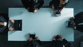Top down aerial view of diverse data analysts wearing VR headset and stand around table while using hand gestures to manipulate the data streamed live from executive manager's laptop. Directorate. - Powered by Shutterstock - Get 15% off with code: PIKWIZARD15