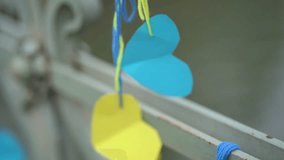 Two paper hearts in yellow and blue colors hang on strings and move in the wind on a bridge. Symbol of Ukraine, national colors, simple handmade decoration outdoors. 4K video, Germany. - Powered by Shutterstock - Get 15% off with code: PIKWIZARD15