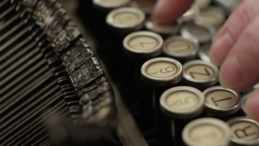 Fingers typing on keyboard of old vintage typewriter close-up