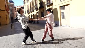 Two young male dancers performing an expressive contemporary dance routine together on a cobblestone street in a historic european city, showcasing fluid movements and artistic partnership - Powered by Shutterstock - Get 15% off with code: PIKWIZARD15