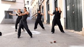 Talented group of four dancers in black outfits performing a synchronized contemporary and hip hop choreography in a european city street, showing their passion for urban dance culture - Powered by Shutterstock - Get 15% off with code: PIKWIZARD15