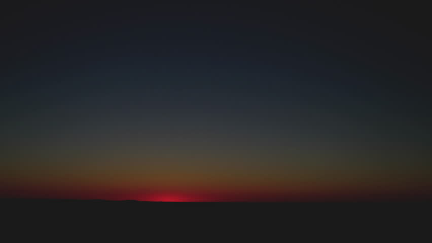 Fast sunrise over an open landscape in this wide cinematic timelapse featuring a clean horizon and expansive sky. The sun rises quickly above the distant horizon, casting warm golden light across the scene while the sky transitions from deep blue to soft orange and amber tones. The minimal composition emphasizes simplicity, openness, and natural beauty.

The wide-angle view provides a large amount of copy space, making this footage ideal as a background or video backdrop for a variety of creative uses. Subtle atmospheric haze near the horizon adds depth, while the smooth timelapse motion highlights the passage of time and the transition from night to day.

This clip is perfect for projects related to nature, travel, environment, and outdoor landscapes. It also works exceptionally well for corporate videos, commercials, social media content, and presentations requiring a clean, unobstructed sky or sunrise background. The simple composition allows for easy integration of text, graphics, and overlays.

The scene conveys themes of new beginnings, hope, opportunity, and the start of a new day. Its calm and uplifting tone makes it suitable for inspirational storytelling, wellness content, and motivational messaging.

Concepts include sunrise, horizon, sky, timelapse, landscape, nature, background, copy space, dawn, morning, light, atmosphere, environment, and natural beauty. High-quality footage suitable for professional video production and commercial use.