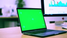 Desk scene with dual monitors one green screen laptop - Powered by Shutterstock - Get 15% off with code: PIKWIZARD15