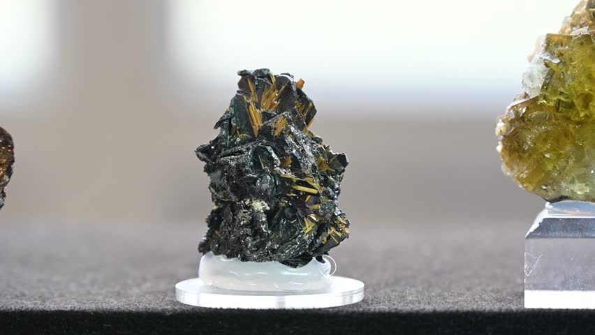 Crystals and minerals on display at the fair. Close-up of crystals. Hematite golden rutile.