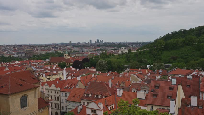 Summer cityscape of Prague with red rooftops.