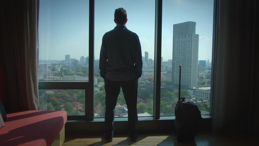 Contemplative Traveler Deep in Thought Gazing at the Stunning City View from Hotel Room