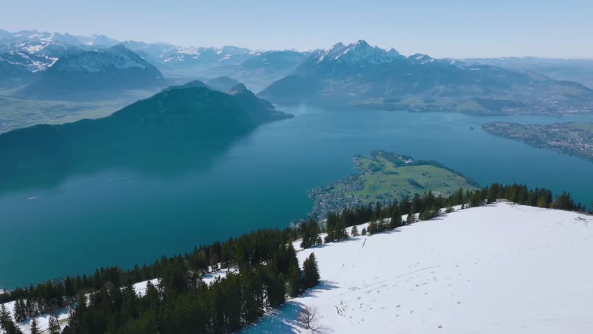 Breathtaking view of a snowy mountain peak surrounded by mist and pine forests. A serene winter scene capturing the beauty, calm, and grandeur of nature in its purest form.