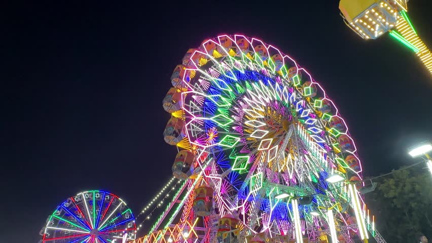 Video of Ferris Wheel or Joint wheel ride running under blue sky at fair ground during the annual fair.