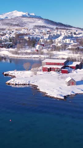 Experience the breathtaking beauty of Tromso, Norway during winter. Discover the serene beaches, icy waters, and snow-capped mountains and fishing village.