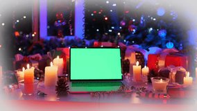 Laptop with green screen on desk with candles, pine cones, and Christmas gifts. Cozy holiday atmosphere and festive background for design projects. - Powered by Shutterstock - Get 15% off with code: PIKWIZARD15