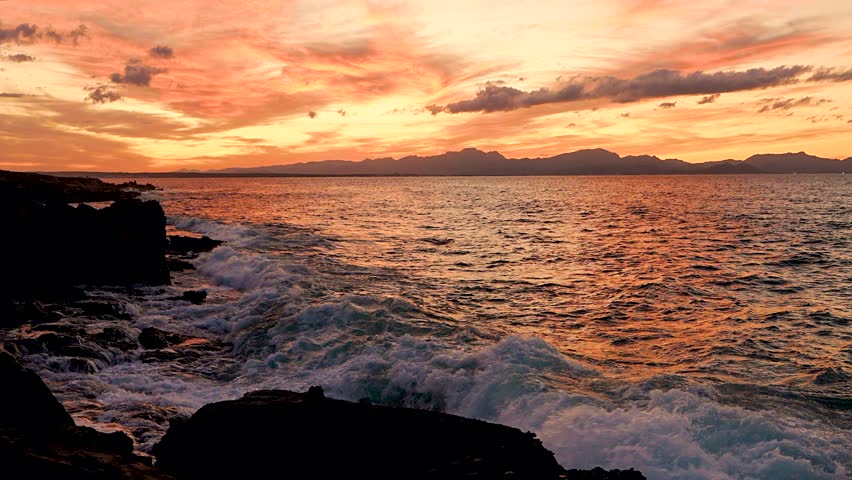 Scenic sunset over the rocky coastline of Mallorca, Spain. Slow motion.  Travel, relaxation, background,  nature visuals. 