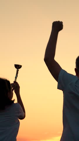 Team victory father young champion daughter. Father child celebrate victory, winner in sports, concept of life success. Silhouette happy champion. Athletic father, child daughter holding gold cup, sky