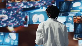 Happy doctor doing key note presentation on medical research data and 3D anatomy models dashboards. Joyous woman showing futuristic medical visuals on multimedia wall during conference, camera B - Powered by Shutterstock - Get 15% off with code: PIKWIZARD15