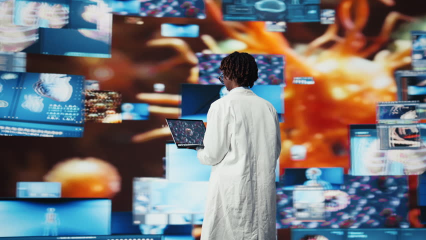 Epidemiologist reviewing viral mutation models on notebook screen. Scientist analyzing 3D virus structure on laptop to support vaccine development, surrounded by medical dashboards, camera A - Powered by Shutterstock - Get 15% off with code: PIKWIZARD15