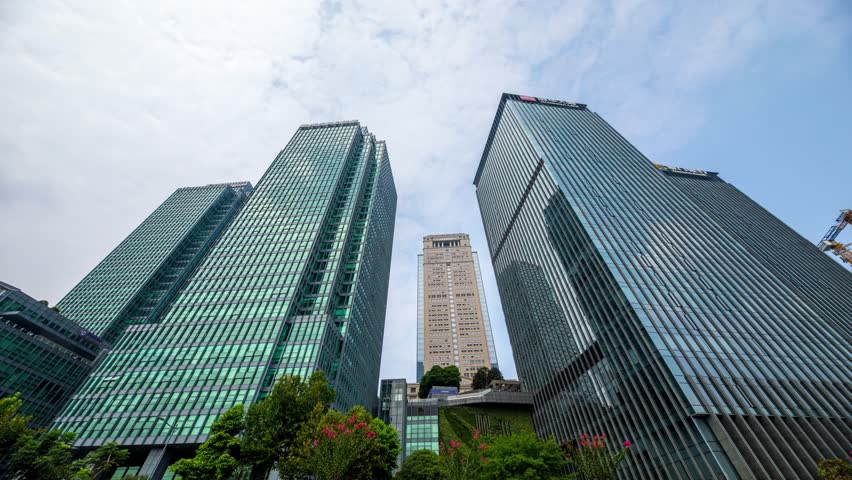 Modern skyscrapers and office buildings in Chongqing CBD business district, China, with contemporary glass architecture against blue sky and green landscaping