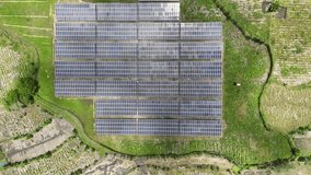Aerial top-down drone view of a large solar panel farm generating renewable energy in a lush green rural landscape. Vertical video. - Powered by Shutterstock - Get 15% off with code: PIKWIZARD15