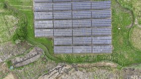 Aerial top-down view of a large solar panel farm in a rural green landscape. Renewable energy production concept. - Powered by Shutterstock - Get 15% off with code: PIKWIZARD15