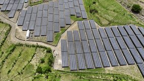 Aerial view of a large solar panel farm generating renewable energy in a lush green rural landscape. - Powered by Shutterstock - Get 15% off with code: PIKWIZARD15