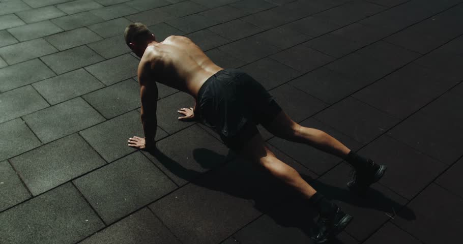 Fitness and sport lifestyle. Sports, health care, fitness routine, workout. Strength, motivation. Outdoors gym. Sportsman muscular strong guy bodybuilder do push-ups exercise pumping biceps arms