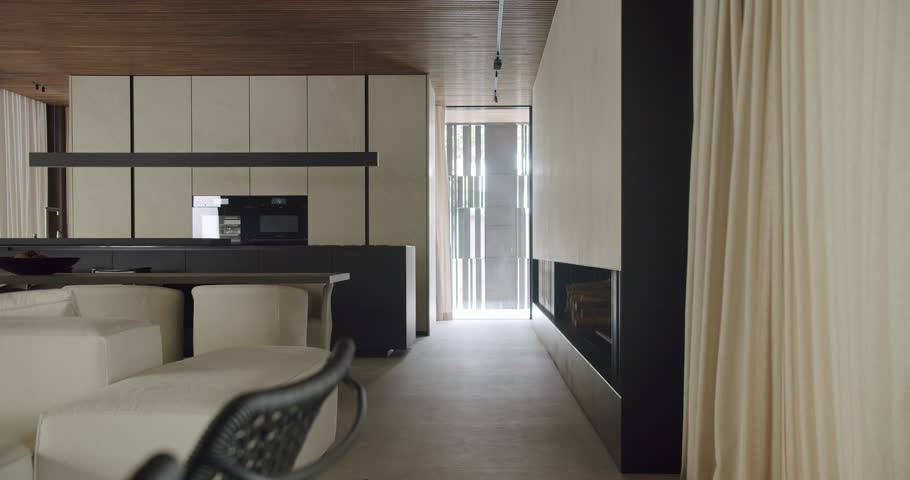 A stylish man walks through a modern, well-appointed home with elegant, minimalistic decor, emphasizing luxury and comfort. Man Walking in Modern Stylish Home Interior, Elegant Design
