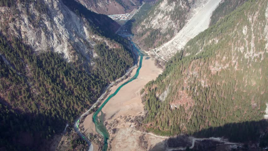 Drone view of Jiuzhaigou National Park in spring in Sichuan Province China. It features cascading waterfalls, turquoise blue lakes, and stunning mountain valleys. 4K real time footage travel concept.