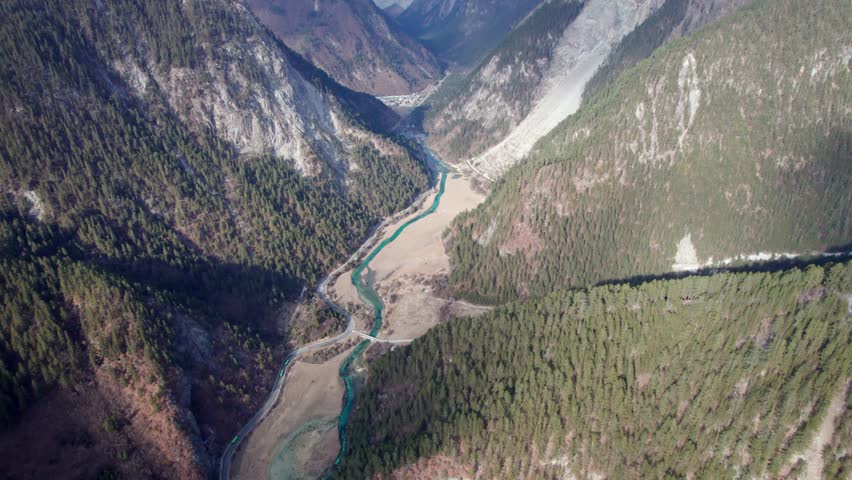 Drone view of Jiuzhaigou National Park in spring in Sichuan Province China. It features cascading waterfalls, turquoise blue lakes, and stunning mountain valleys. 4K real time footage travel concept.