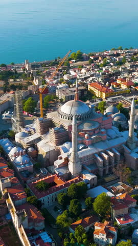 Vertical video. Istanbul, Turkey. Hagia Sophia Mosque in Fatih district panoramic drone view over sea with morning sunrise light. Aerial View, MasterShots, Circle (Far). Rich colors